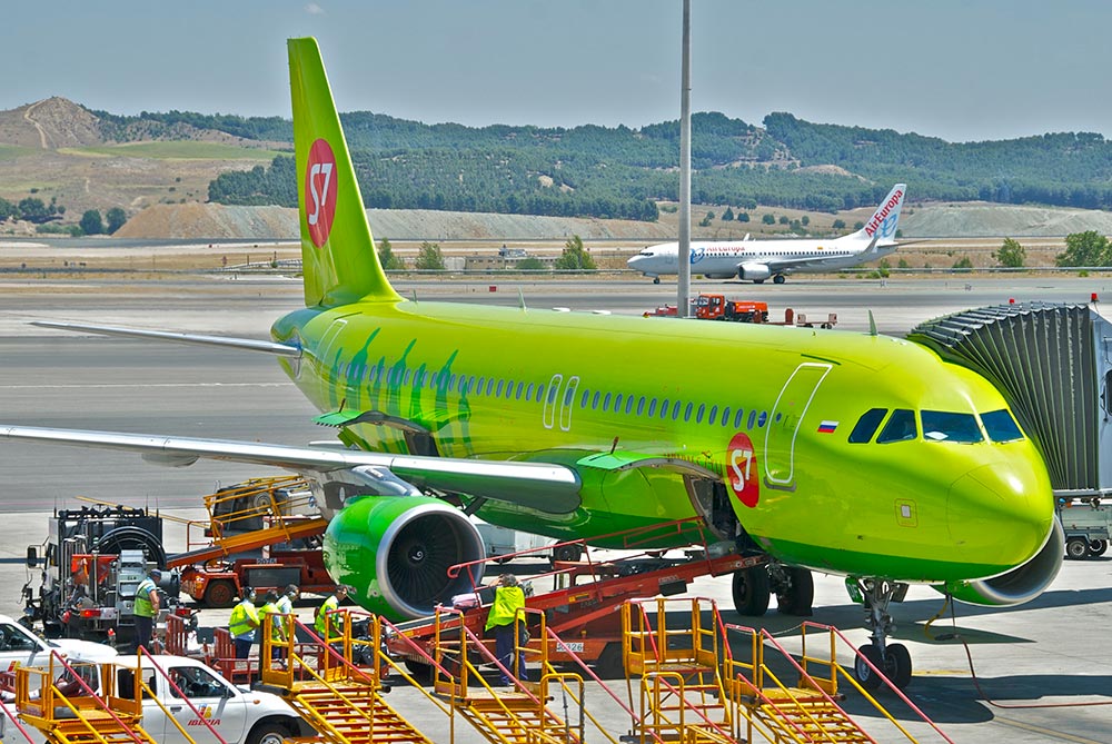 aeroplano s7 airlines mentre carica i bagagli in stiva